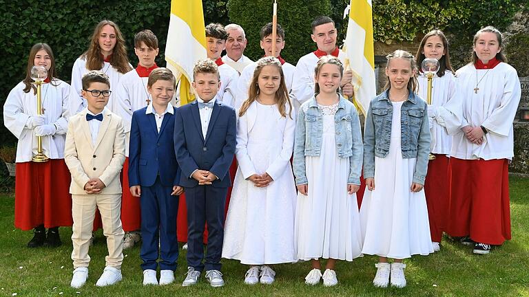 Auf dem Foto sind die Kommunionkinder mit Pfarrer Stefan Mai und Ministranten zu sehen. Die Kommunionkinder sind von links: David Martinas, Leonard Krapf, Jeremias Pfaff, Rosa Schwab, Enie Gernert und Marie Schulz.