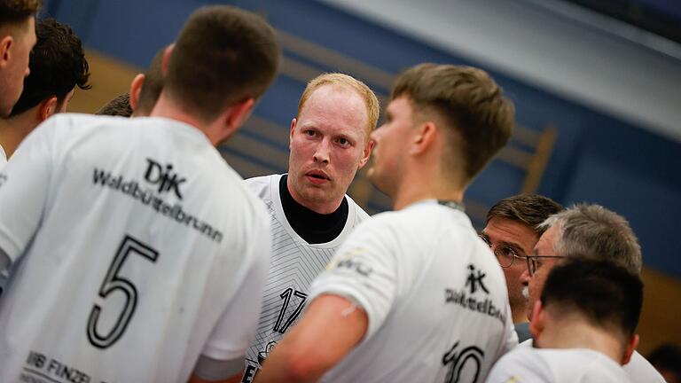 Julian Bötsch (Bildmitte) im Spiel gegen die TG Landshut bei einer Besprechung während einer Auszeit: Der Trainer der DJK Waldbüttelbrunn hat seinen Vertrag verlängert und will in der kommenden Saison auf eigene Einsätze auf dem Spielfeld ganz verzichten.