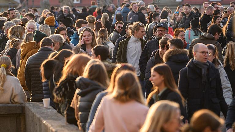 Der Frühling ist da: Zahlreiche Menschen bevölkerten am Samstag die Alte Mainbrücke in Würzburg. In Unterfranken stecken sich immer noch viele Menschen mit dem Coronavirus an.