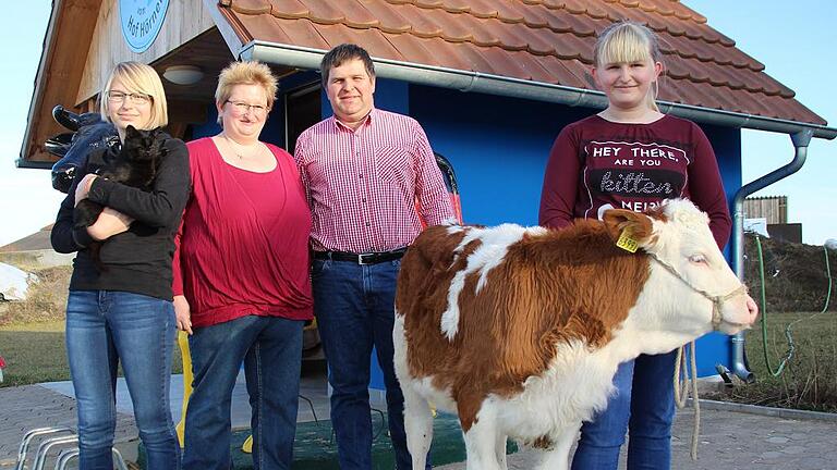 Gruppenbild mit Kälbchen: Sabine und Bernd Hörner mit zwei der drei Töchter sowie der drei Monate alten Moni vor der Milchtankstelle am Ortsrand von Kleinlangheim. Seit einem Jahr gibt's hier Milch rund um die Uhr.