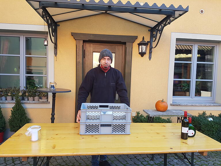 Winzer und Gastwirt Björn Grebner steht im Innenhof des Patrizierhofs, ein Gasthof, Hotel und Weingut in Großlangheim (Lkr. Kitzingen). Wo bis in dem Spätsommer noch Gäste saßen, hat der Familienbetrieb wie schon im ersten Lockdown einen Drive-Through eingerichtet. Vorbestelltes Essen kann so schnell ins Auto geladen und zuhause gegessen werden. Winzer und Gastwirt Björn Grebner steht im Innenhof des Patrizierhofs, ein Gasthof, Hotel und Weingut in Großlangheim (Lkr. Kitzingen). Wo bis in dem Spätsommer noch Gäste saßen, hat der Familienbetrieb wie schon im ersten Lockdown einen Drive-Through eingerichtet. Vorbestelltes Essen kann so schnell ins Auto geladen und zuhause gegessen werden.
