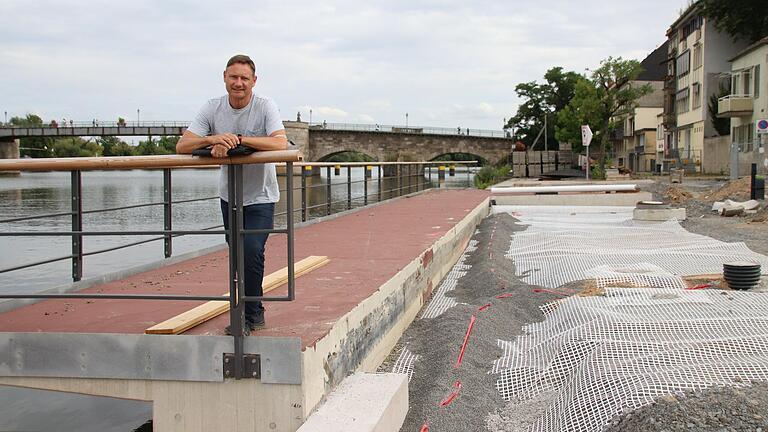 Tobias Haupt, Projektverantwortlicher vom Bauamt Kitzingen, steht auf dem neuen Balkon, der über den Main ragt. Das weiße Netz im Boden ist ein Geogitter aus Kunststoff, das zu starke Setzungen des Materials verhindern soll. Tobias Haupt, Projektverantwortlicher vom Bauamt Kitzingen, steht auf dem neuen Balkon, der über den Main ragt. Das weiße Netz im Boden ist ein Geogitter aus Kunststoff, das zu starke Setzungen des Materials verhindern soll.