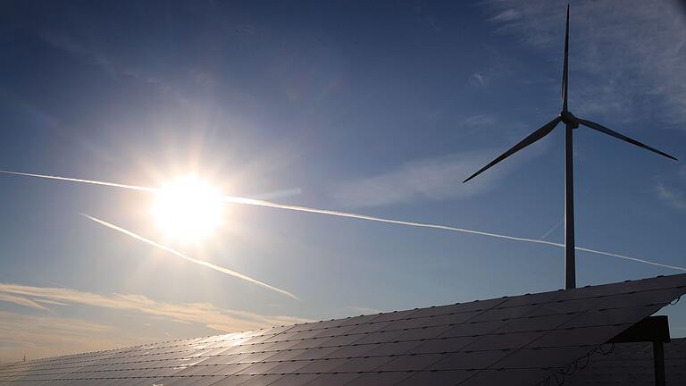 Windrad hinter Solarkraftanlage       -  Wind und Sonne als wichtige Energiequellen: Rekord für Ökostromproduktion in Deutschland (Archivbild)