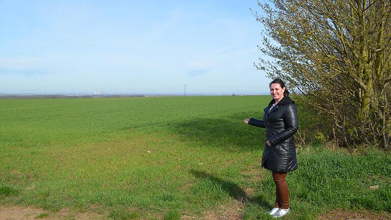 Hier soll das Baugebiet 'Mönchstockheimer Weg IV' entstehen. Im Bild Bürgermeisterin Nicole Weisseseel-Brendler an der Hecke, die im Zug der Erschließung verpflanzt werden soll.