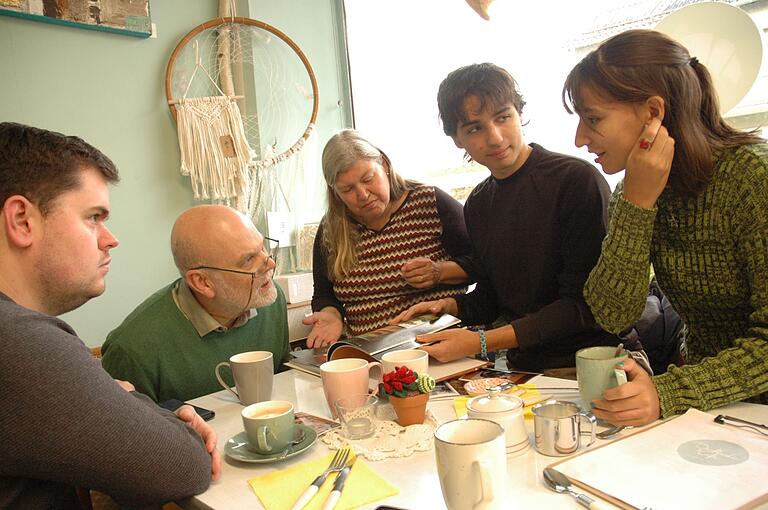 Bei einer Tasse Kaffee im Dorfladen unterhalten sich Manuel Schmitt (2. Bürgermeister), Bürgermeister Gunther Ehrhardt, Analia Langmandel und die Kinder Daniel und Paula.