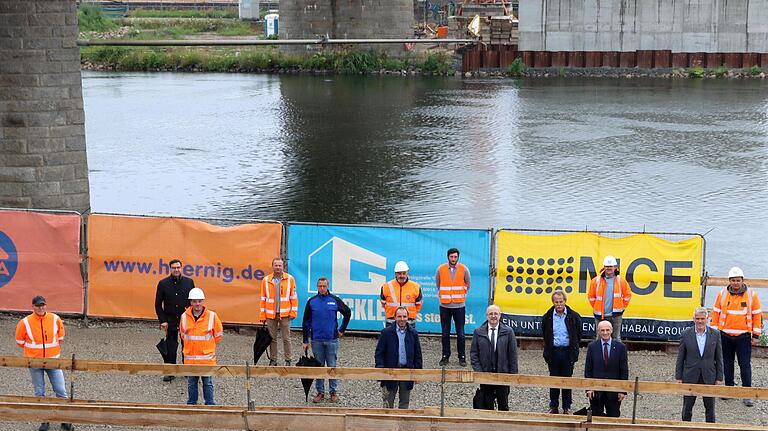 Am Ortstermin des Staatlichen Bauamtes mit Behördenleiter Michael Fuchs (6. von rechts) an der Baustelle der neuen Mainbrücke bei Horhausen nahmen Vertreter der bauausführenden Firmen sowie (vorne von rechts) die Kommunalpolitiker MdL Steffen Vogel, Landrat Wilhelm Schneider, MdL Paul Knoblach sowie der Thereser Bürgermeister Matthias Schneider teil.