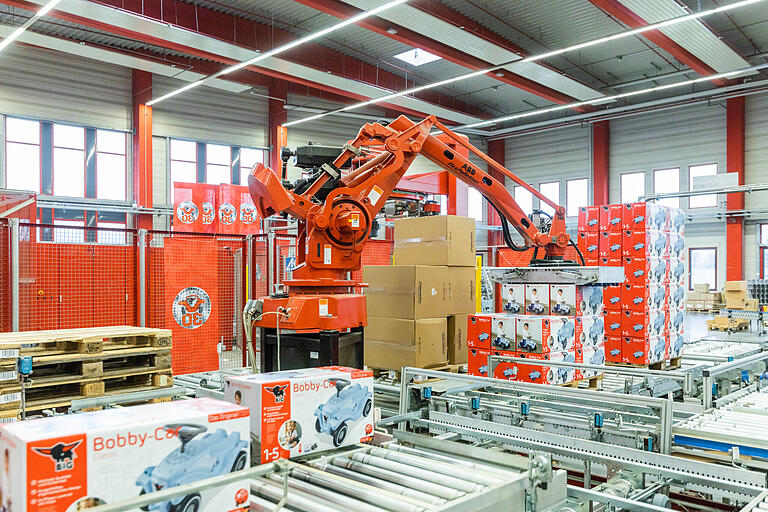 Ein Palettierroboter setzt die fertigen Pakete auf Paletten, wo sie im Anschluss in Folie gewickelt werden. Danach folgt der letzte Schritt: die Logistik.