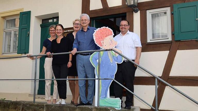 Paul Maar und sein Sams (Mitte) freuen sich über den neuen Ort für das 'Samselsurium' in Hallstadt mit (von rechts) Bürgermeister Thomas Söder, Akademiepräsidentin Claudia Maria Pecher, Museumskuratorin Dagmar Stonus und Melanie Dirauf vom Sankt Michaelsbund im Erzbistum Bamberg.