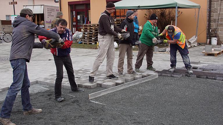 Auf dem Dorfplatz in Unterschleichach haben viele freiwillige Helfer angepackt, um ein besser begehbares Pflaster zu verlegen. Die Arbeiten liefen Hand in Hand.