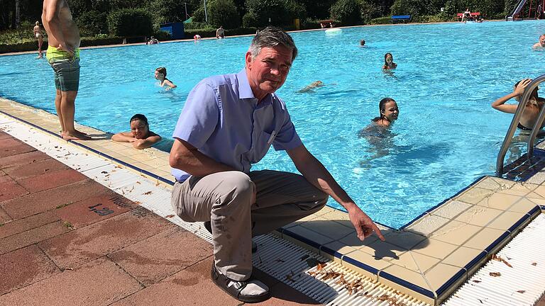 Im Volkacher Freibad im Sommer 2018: Bürgermeister Peter Kornell zeigt auf eine von vielen schadhaften Stellen.