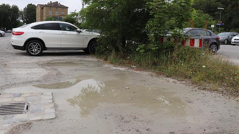Zum Umfeld des Kitzinger Bahnhofs gehört ein unbefestigter Pendlerparkplatz. Mal steht dort das Wasser, mal weht einem der Staub ins Gesicht. Zum Umfeld des Kitzinger Bahnhofs gehört ein unbefestigter Pendlerparkplatz. Mal steht dort das Wasser, mal weht einem der Staub ins Gesicht.
