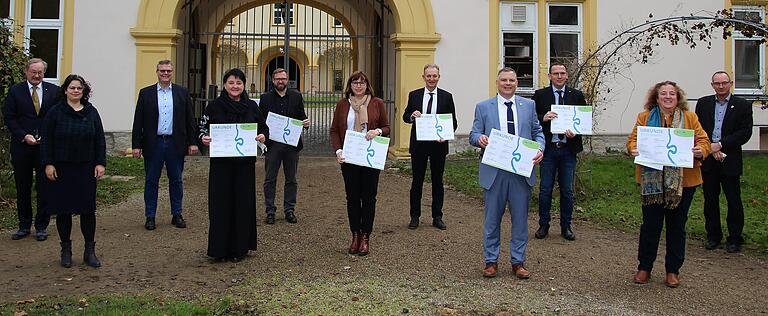 Im Gaibacher Schlossgarten präsentierten die Mainschleife-Plus-Beteiligten stolz die unterzeichneten Urkunden (von links): Peter Doneis (ALE), Carina Hein (ILE), Markus Höfling (ALE), Lisa Krein (Schwanfeld), Christian Holzinger (Eisenheim), Sibylle Säger (Nordheim), Horst Herbert (Kolitzheim), Heiko Bäuerlein (Volkach), Tobias Blesch (Wipfeld), Elisabeth Drescher (Sommerach) und Gerhard Wagenhäuser (Geschäftsstellenleiter Volkach). Im Gaibacher Schlossgarten präsentierten die Mainschleife-Plus-Beteiligten stolz die unterzeichneten Urkunden (von links): Peter Doneis (ALE), Carina Hein (ILE), Markus Höfling (ALE), Lisa Krein (Schwanfeld), Christian Holzinger (Eisenheim), Sibylle Säger (Nordheim), Horst Herbert (Kolitzheim), Heiko Bäuerlein (Volkach), Tobias Blesch (Wipfeld), Elisabeth Drescher (Sommerach) und Gerhard Wagenhäuser (Geschäftsstellenleiter Volkach).