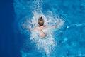Schwimmbad       -  Ein Junge springt in einem Freibad ins Wasser.