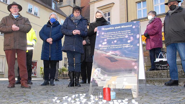 Knapp 40 Frauen und Männer kamen zur Mahnwache 'Empathie statt Missmut' vor dem Kitzinger Kiliansbrunnen, um sich mit Corona-Opfern, der Blaulichtfamilie sowie Beschäftigten im Gesundheits- und Pflege-Bereich zu solidarisieren. Links: Initiator Uwe Hartmann.