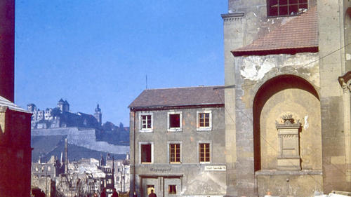 Glühende Hitze lag im Sommer 1947 über der Stadt. Auf den Feldern verdorrte die Ernte, viele Menschen hungerten. Das Foto von Harald Zoepffel stammt aus dem Buch 'Würzburg - Bilder aus einer versunkenen Zeit'. Der Blick geht vom Kiliansplatz über die Domstraße zur Festung. Links ist der Dom zu erkennen, rechts das Neumünster; Im Notbau in der Mitte ist die Städtische Sparkasse untergebracht. Glühende Hitze lag im Sommer 1947 über der Stadt. Auf den Feldern verdorrte die Ernte, viele Menschen hungerten. Das Foto von Harald Zoepffel stammt aus dem Buch 'Würzburg - Bilder aus einer versunkenen Zeit'. Der Blick geht vom Kiliansplatz über die Domstraße zur Festung. Links ist der Dom zu erkennen, rechts das Neumünster; Im Notbau in der Mitte ist die Städtische Sparkasse untergebracht.