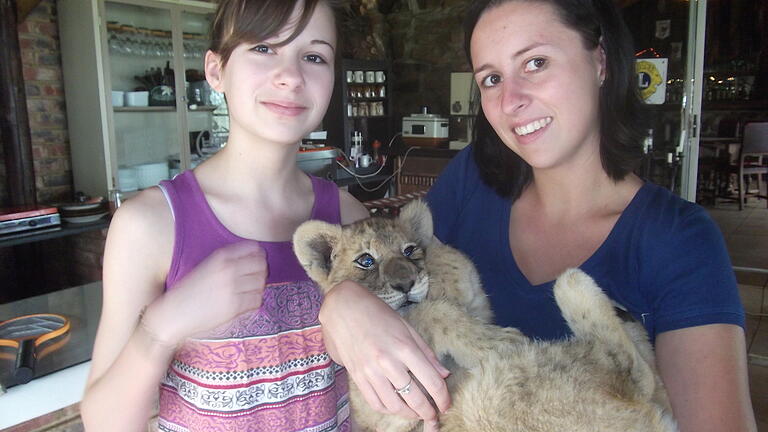 Anna Riedmann (rechts) mit einem Gepardenbaby und ihrer Schwester Sophie bei deren Besuch in Südafrika