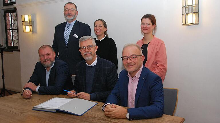 Bei der Vertragsunterschrift im Rittersaal (oben): Familienstützpunkt-Leiterin Paula Geßner (rechts), Claudia Ruhe (Landratsamt) und Michael Schumacher (Jugendamt). Unten (v.l.): Landrat Thomas Eberth,&nbsp; Bürgermeister Bernhard Weidner und AWO-Bezirksgeschäftsführer Martin Ulses.