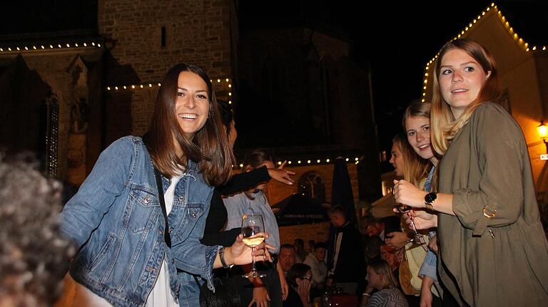 Ein Tänzchen auf den Bänken wagten diese Weinfestbesucherinnen am Freitagabend, eingerahmt von der imposanten Giebelbeleuchtung am Marktplatz.