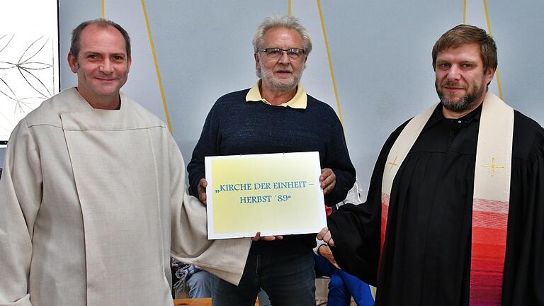 Ralf Luther, Vorsitzender des Vereins Autobahnkirche Bibra A 71 (Mitte), bei der offiziellen Namensgebung der Kirche. Symbolisch überreichte er die kleine Tafel an den evangelischen Pfarrer Michael Schlauraff (Bibra, rechts) und Pastoralreferent Ulrich Emge (Mellrichstadt, links). Ralf Luther, Vorsitzender des Vereins Autobahnkirche Bibra A 71 (Mitte), bei der offiziellen Namensgebung der Kirche. Symbolisch überreichte er die kleine Tafel an den evangelischen Pfarrer Michael Schlauraff (Bibra, rechts) und Pastoralreferent Ulrich Emge (Mellrichstadt, links).