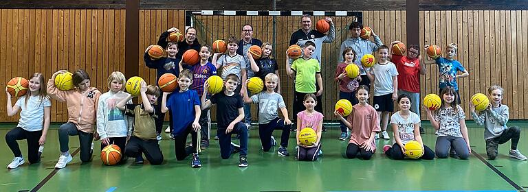 Die 3a der Grundschule Markt Einersheim beim Training mit den Baskets. In der hintersten Reihe: Schulleiter Matthias Schuhmann, Jochen Freier von den Baskets und die beiden Trainer Steven Hutchinson und Malcolm Streitberg (von links).