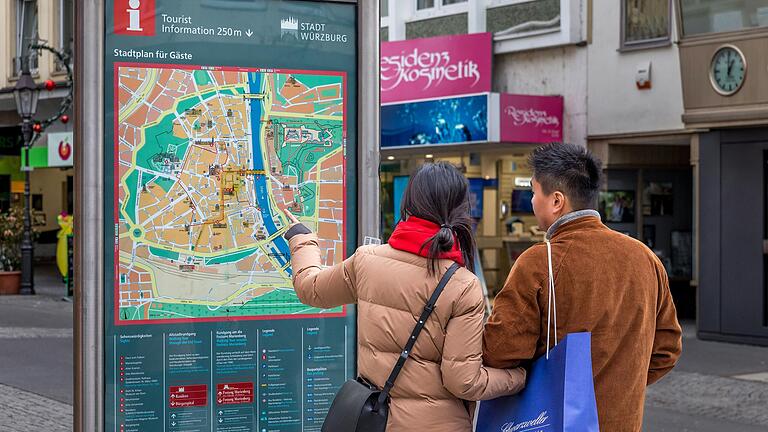 Zwei Touristen stehen in der Würzburger Innenstadt vor einem Stadtplan. Die Übernachtungszahlen in Würzburg sind im Vorjahr wieder gestiegen.