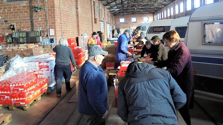 Das Foto zeigt die Helfer des Vereins beim Packen von 450 je ca. 13 kg schweren Lebensmittelpaketen in der ehemaligen Zieglerei Gessner Lebenhan.