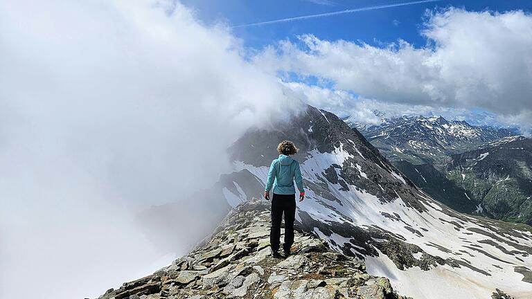 Wolken tanzen um den Fels, der Blick reicht weit über schneebefleckte Bergriesen. Wolken tanzen um den Fels, der Blick reicht weit über schneebefleckte Bergriesen.