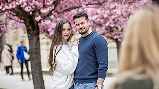 Einige Menschen tummeln sich am Sonntag (13.04.25) im Hofgarten der Residenz in Würzburg. Die Kirschblüte lockt jedes Jahr im April viele Besucher in die Gartenanlage.