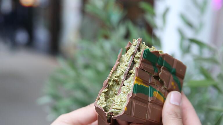 Eine gebrochene Tafel 'Dubai-Schokolade' von 'Kikis Kitchen' - Foodtrend aus Dubai: Die sogenannte „Dubaischokolade“ ist eine neue, luxuriöse Variante der Vollmilchschokolade - Sie ist mit Pistaziencreme und Engelshaar gefüllt. Eine gebrochene Tafel 'Dubai-Schokolade' von 'Kikis Kitchen' - Foodtrend aus Dubai: Die sogenannte „Dubaischokolade“ ist eine neue, luxuriöse Variante der Vollmilchschokolade - Sie ist mit Pistaziencreme und Engelshaar gefüllt.