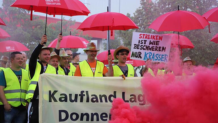 Rote Rauchwoliken, rote Schirme, klare Forderungen: Der Streik im Kaufland-Lager in Donnersdorf geht über mehr als zwei Tage und wird erst am Mittwochnacht enden.