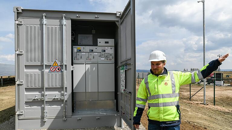 Projektingenieur Benedikt Bausenwein erklärt die Steuerungseinheit, mit der der Stromfluss von der Anlage ins Stromnetz geregelt wird.