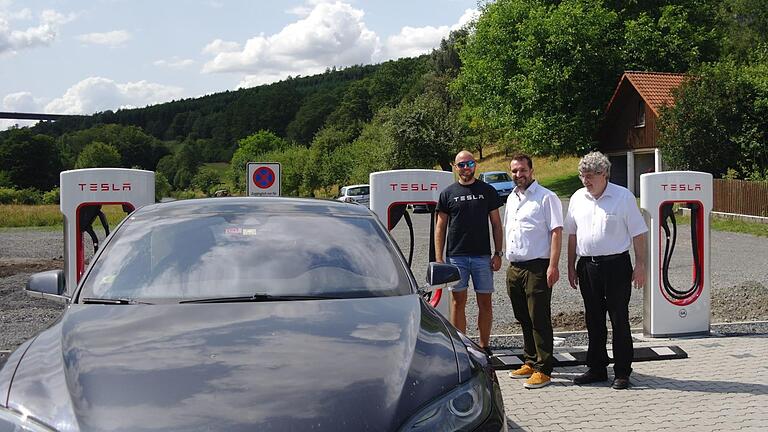 Testweise lud Jan Pavluk, Techniker bei Tesla (links), beim Pressetermin schon mal das Firmenauto. Harald und Gerd Ziegler freuen sich über den neuen 'Anschluss' - wörtlich wie sprichwörtlich.  Foto: Stephanie Elm       -  Testweise lud Jan Pavluk, Techniker bei Tesla (links), beim Pressetermin schon mal das Firmenauto. Harald und Gerd Ziegler freuen sich über den neuen 'Anschluss' - wörtlich wie sprichwörtlich.  Foto: Stephanie Elm