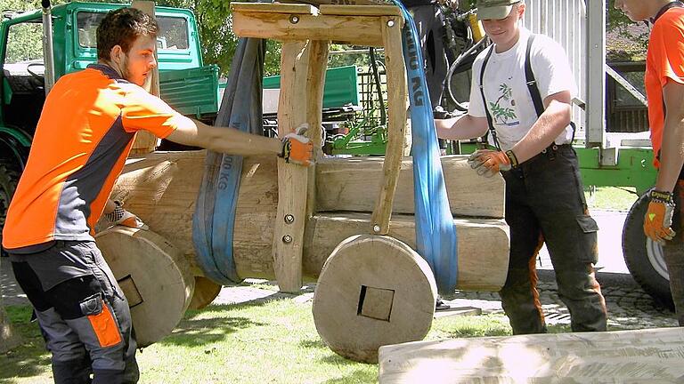 Holzeisenbahn für die Schule im Taubertal gebaut       -  (ret)   Die Forstwirt-Azubis des Landratsamtes Main-Tauber-Kreis haben mit ihrem Ausbilder Stefan Brameier eine Holzeisenbahn für die Schule im Taubertal und den Schulkindergarten in Unterbalbach hergestellt. Das Eichenholz konnte in Unterbalbach geschlagen werden und wurde von Förster Ulrich Stier zur Verfügung gestellt, so eine Pressemitteilung des Landratsamtes. An der Eiche mussten zunächst die Rinde und das Splintholz mit der Motorsäge heruntergesägt werden, so dass das viel härtere Kernholz übrigblieb. Wie die Eisenbahn später aussehen sollte, wurde anhand eines Bildes von den Azubis und Stefan Brameier auf das Holz übertragen. Das Motiv hatte Barbara Barthel, die Leiterin des Schulkindergartens, zur Verfügung gestellt. Im Anschluss wurden mit der Motorsäge das Führerhaus, die Lokomotive und die Waggons grob bearbeitet und danach mit einem Bandschleifer geschliffen. Für Stefan Brameier und seine drei Azubis war der Bau des Spielgerätes eine Abwechslung zu der umfangreichen forstlichen Ausbildung. Diese sieht unter anderem den Bau von Erholungseinrichtungen oder Holzbearbeitung vor, so dass die Herstellung der Eisenbahn in den Ausbildungsplan passte. Die Arbeiten wurden von Harald Lurz vom Landratsamt mit organisiert und geplant.