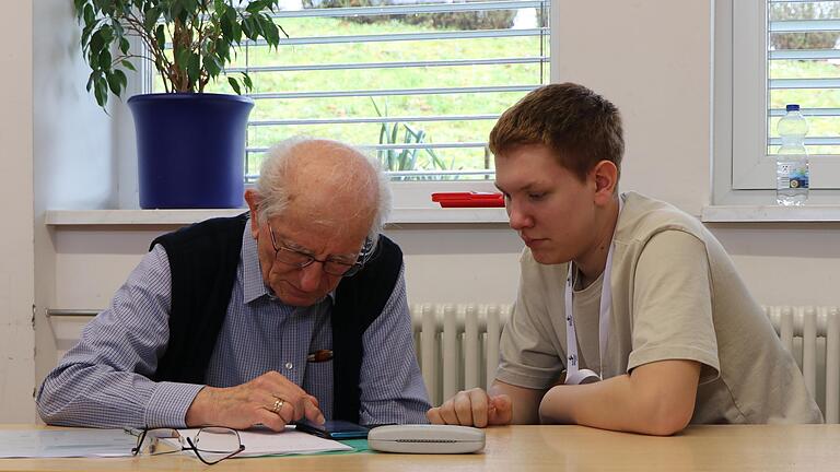 Max Appelmann (rechts) erklärt Peter Keller das Smartphone: Die Mittelschule Eußenheim hat Hilfe für Erwachsene angeboten.