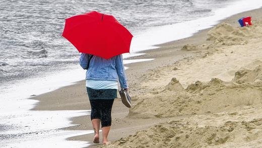 Abruptes Ende des Hochsommers: Urlauberin beim einsamen Strandspaziergang auf der Ostseeinsel Usedom.