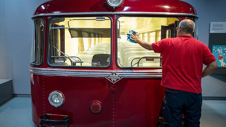 Dauerausstellung 'Im Deutschland der zwei Bahnen'       -  Ein Mitarbeiter im DB Museum putzt die Scheibe eines Schienenbusses aus den 50er Jahren in der Dauerausstellung&bdquo;Im Deutschland der zwei Bahnen&rdquo;.