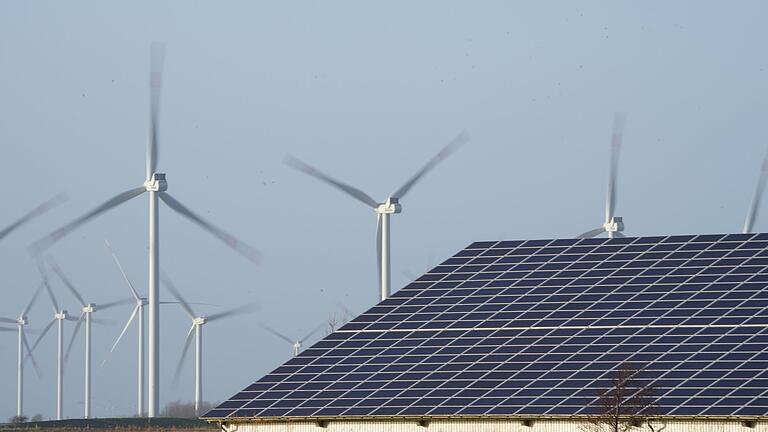 Windenergieanlagen.jpeg       -  Windenergieanlagen stehen neben einer Halle mit Photovoltaik-Anlagen.