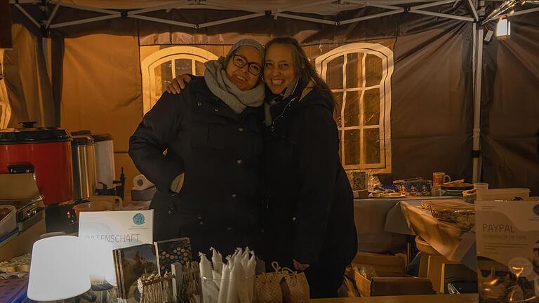 Stefanie Richter und Kristin Käppner von vita est cara e.V. freuen sich über das große Interesse an Tierschutzthemen auf dem 'fairliebt Weihnachtsmarkt' auf dem Rathaushof in Boxberg.