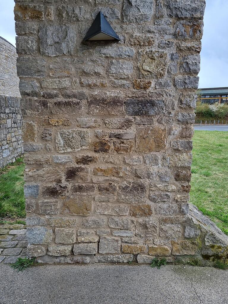 Die Mauer nach dem ersten gescheiterten Versuch der Fachfirma. Der Unterbodensprühlack war so hartnäckig, dass eine Spezialreinigung mit Trockeneis zum Einsatz kam.