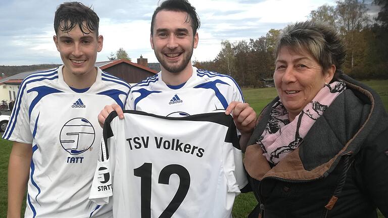 TSV-Volkers-Vorsitzende Claudia Karg überreichte dem scheidenden Evhenii Stoianov unter anderem ein Trikot mit persönlicher Namensbeflockung. Links Kapitän Nico Ipek, der ihm bei seinem 'Abschiedsspiel' gegen Obereschenbach die Binde überließ. Foto: Hans-Peter Ehrensberger       -  TSV-Volkers-Vorsitzende Claudia Karg überreichte dem scheidenden Evhenii Stoianov unter anderem ein Trikot mit persönlicher Namensbeflockung. Links Kapitän Nico Ipek, der ihm bei seinem 'Abschiedsspiel' gegen Obereschenbach die Binde überließ. Foto: Hans-Peter Ehrensberger