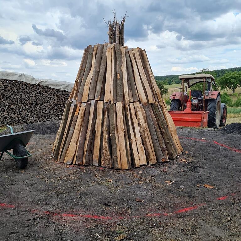 Nachdem der Docht eingebaut wurde (oben mitte), werden die Holzscheite ringsum geschlichtet. 14 Ster Buchenholz wurden dieses Jahr dazu verwendet. Der rote Kreis markiert das Ausmaß des fertigen Kohlenmeilers. Nachdem der Docht eingebaut wurde (oben mitte), werden die Holzscheite ringsum geschlichtet. 14 Ster Buchenholz wurden dieses Jahr dazu verwendet. Der rote Kreis markiert das Ausmaß des fertigen Kohlenmeilers.