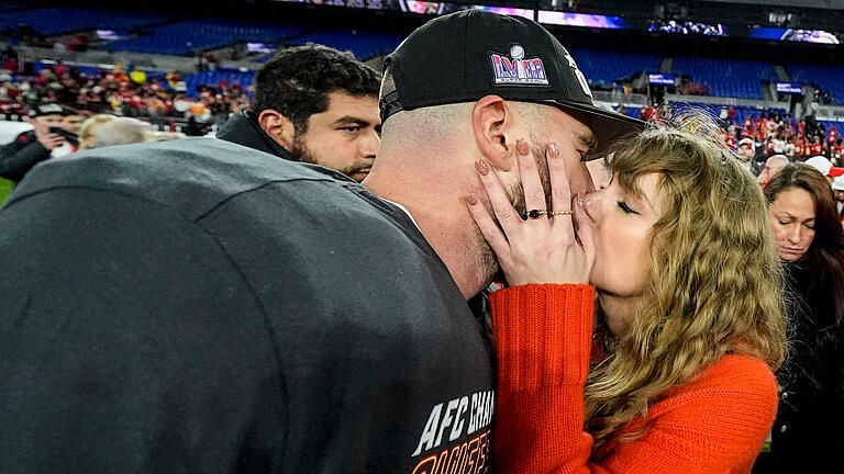 Baltimore Ravens - Kansas City Chiefs.jpeg       -  Die Musikerin Taylor Swift küsst Kansas City Chiefs Tight End Travis Kelce nach einem NFL-Footballspiel auf dem Spielfeld. Aufgeregte Debatten folgen.