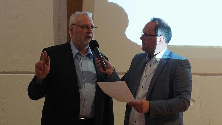 Gerhard Kraft (links) legt gegenüber Bürgermeister Michael Hombach (rechts) und dem versammelten Stadtrat seinen Eid zur Aufnahme ins Gremium ab.