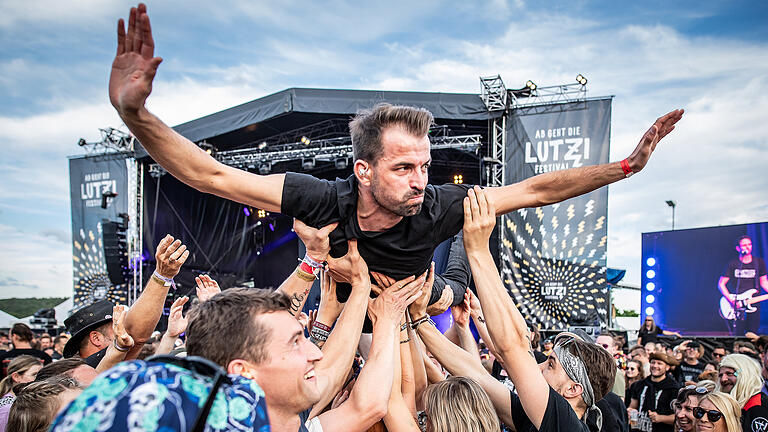 Crowdsurfing: der Schlagzeuger von der Punkband 'MONTREAL' läßt sich am Freitag 28.06.24 beim Festival 'ab geht die Lutzi!' in Rottershausen (Kreis Bad Kissingen) von den Besuchern über das Gelände tragen.