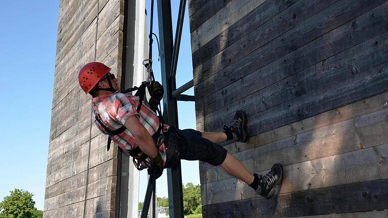 Bauhofmitarbeiter Stefan Schmitt ist der erste, der sich am Kletterturm abseilt. Hier hat er den Abstieg schon fast geschafft. Fotos: Kathrin Kupka-Hahn       -  Bauhofmitarbeiter Stefan Schmitt ist der erste, der sich am Kletterturm abseilt. Hier hat er den Abstieg schon fast geschafft. Fotos: Kathrin Kupka-Hahn