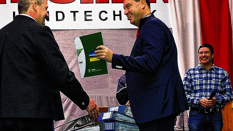 Handfeste Bürokratiekritik: Michael Reck (links) vom Bauernverband überreicht bei der Eröffnung der Frühjahrsmesse in Holzhausen Bayerns Finanzminister Markus Söder einen leeren Aktenordner, auf dass er sich nie fülle. Recks Mitstreiter Andreas Römmert (rechts) freut sich darüber.