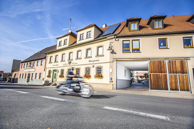 Ein Motorradfahrer fährt an der Brauerei Schwarzer Adler Bräu der Familie Merklein vorbei.