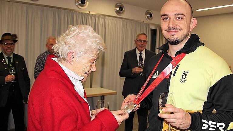 &bdquo;Ganz schön schweres Ding!&ldquo;: Die Mainbernheimerin Ludmilla Eisenbraun durfte Christian Rasps Silbermedaille hautnah begutachten, ebenso wie zuvor Bürgermeister Peter Kraus (Bildmitte, im Hintergrund).  Fotos: Diana FUCHS