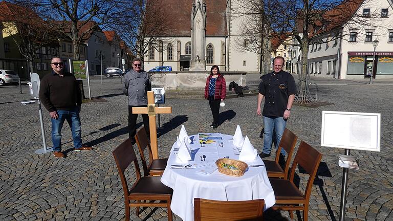 Beisitzer Wolfgang Schober (links), Vorsitzender Michael Bayer (Zweiter von links) und Schriftführer Erec Jacobson (rechts) vom Kreisverband Haßberge des Bayerischer Hotel- und Gaststättenverbandes (DEHOGA Bayern) machten mit einem gedeckten Tisch auf dem Haßfurter Marktplatz auf die prekäre Lage der Gastronomie aufmerksam. Mit auf dem Foto ist Andrea Goger, die zusammen mit ihrem Mann Stefan das Hotel-Weingut Goger in Sand betreibt.