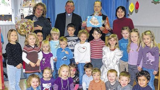 Geldsegen für Kindergarten       -  (jg)   Begeistert empfingen die Buben und Mädchen des katholischen Kindergartens Aura Oliver Wind und Volker Heinz-Losert von der örtlichen Sozialstation. An Kirchweih unterhielten sie im Hof ihres Anwesens eine Verpflegungsstation. Den Erlös stockten sie auf 250 Euro auf und spendierten dem Hort die Summe. Den Kindern brachten sie auch einen Korb voller Süßigkeiten mit. Pfarrer Franz Malczyk und Kindergartenleiterin Luzia Roth freuten sich über den unerwarteten Geldsegen und wollen damit Spielmaterial für den Nachwuchs beschaffen. Inmitten der Kinderschar (von links) sind Volker Heinz-Losert, Pfarrer Franz Malczyk, Oliver Wind und Luzia Roth zu sehen.